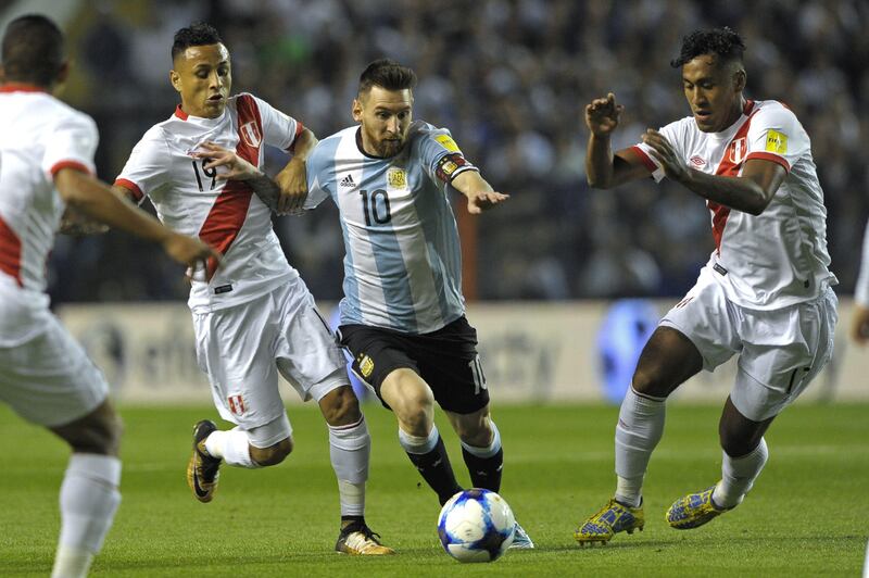 Argentina's Lionel Messi (C) is marked by Peru's Renato Tapia (R) and Victor Yotun during their 2018 World Cup qualifier football match in Buenos Aires on October 5, 2017. / AFP PHOTO / Alejandro PAGNI