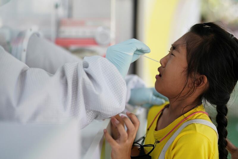 A healthcare worker takes a nasal swab sample from a person, as the country deals with a fresh wave of infections after tackling earlier outbreaks, in Bangkok, Thailand. Reuters