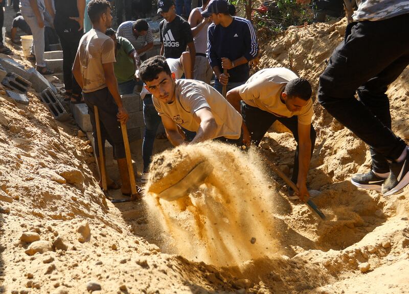 Men dig graves to bury members of the Samour family, who were killed in Israeli strikes on their house in Khan Younis. Reuters