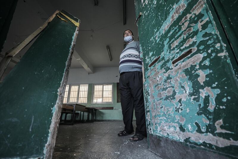 Palestinian inspects a damaged school near a street that Israel reportedly attacked after Palestinian militants fired rockets at Israel, in the east of Gaza city. EPA