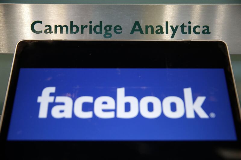 (FILES) In this file photo taken on March 21, 2018 A laptop showing the Facebook logo is held alongside a Cambridge Analytica sign at the entrance to the building housing the offices of Cambridge Analytica, in central London.
Cambridge Analytica, the UK marketing analytics firm at the heart of the Facebook data scandal, announced on May 2, 2018, it was "immediately ceasing all operations" and filing for insolvency in Britain and the United States. "It has been determined that it is no longer viable to continue operating the business," the company, accused of misusing tens of millions of Facebook users' data, said in a statement. / AFP PHOTO / Daniel LEAL-OLIVAS