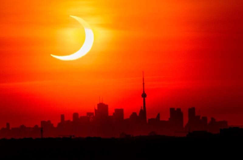An annular solar eclipse rises over the skyline of Toronto. The Canadian Press via AP