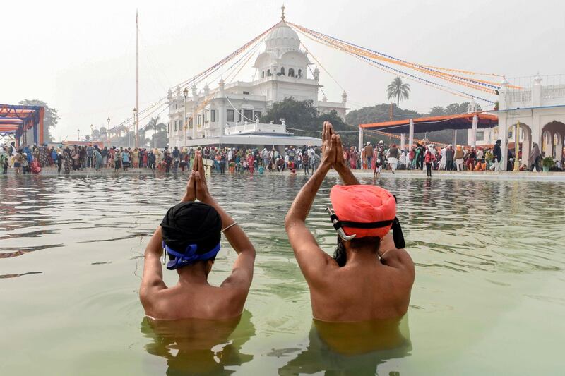 Sikh devotees gesture as they take a dip in a holy sarovar (water tank) on the occasion of the 550th birth anniversary of Guru Nanak Dev at Gurudwara Ber Sahib in Sultanpur Lodhi. AFP