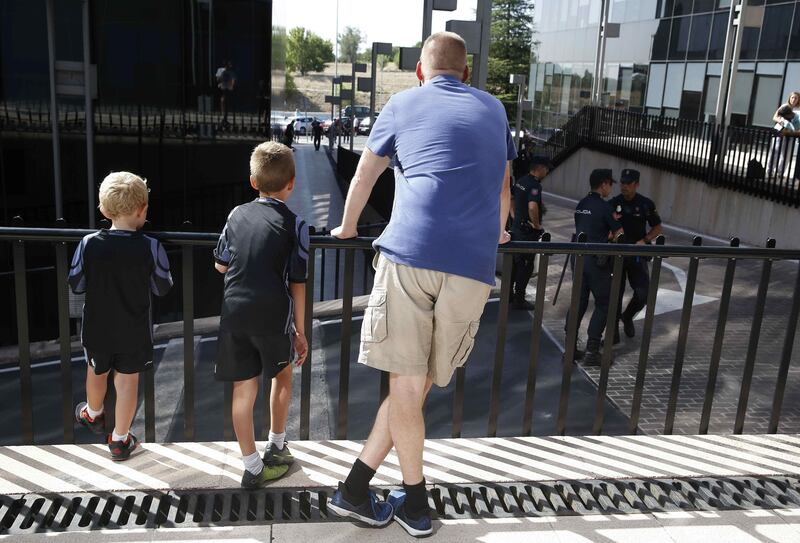 A man and two children wait outside Examining Magistrate's Court No 1, for the arrival of Portuguese footballer Cristiano Ronaldo, in the town of Pozuelo de Alarcon, outside Madrid. Paco Campos / EPA