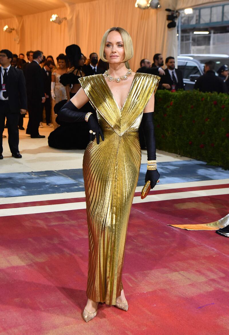 Model and actress Amber Valletta wearing a striking, gold gown. AFP