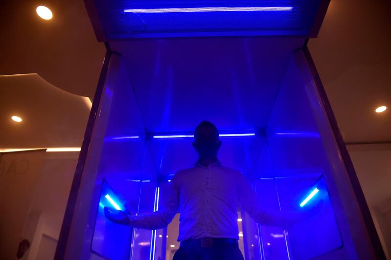 A man performs during the presentation of an automatic disinfection cabin that would help fight the coronavirus, in Bogota. AFP