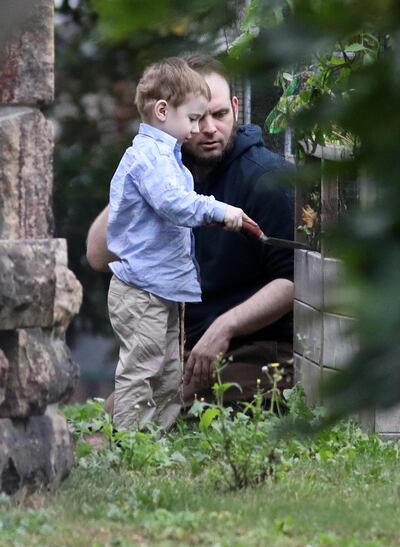 Freed Canadian hostage Joshua Boyle watches as one of his children plays outside the Boyle's family home in Smiths Falls, Ontario, Canada, on October 14, 2017. 
Boyle, whose family was freed from captivity in Pakistan last week, arrived back home early October 14. He accused his kidnappers of murdering his baby daughter and raping his wife during his family's years-long captivity by the Haqqani network, a Taliban-affiliated group operating in Afghanistan and Pakistan. Boyle leveled the accusations in a terse statement he read on arrival in Toronto late October 13 with his American wife, Caitlan Coleman, and three children, who were freed on October 11 by Pakistani troops.   / AFP PHOTO / Mike CARROCCETTO
