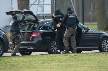 An unidentified person is brought to court by police officers after German authorities broke up an alleged right-wing terror group. DPA/AP