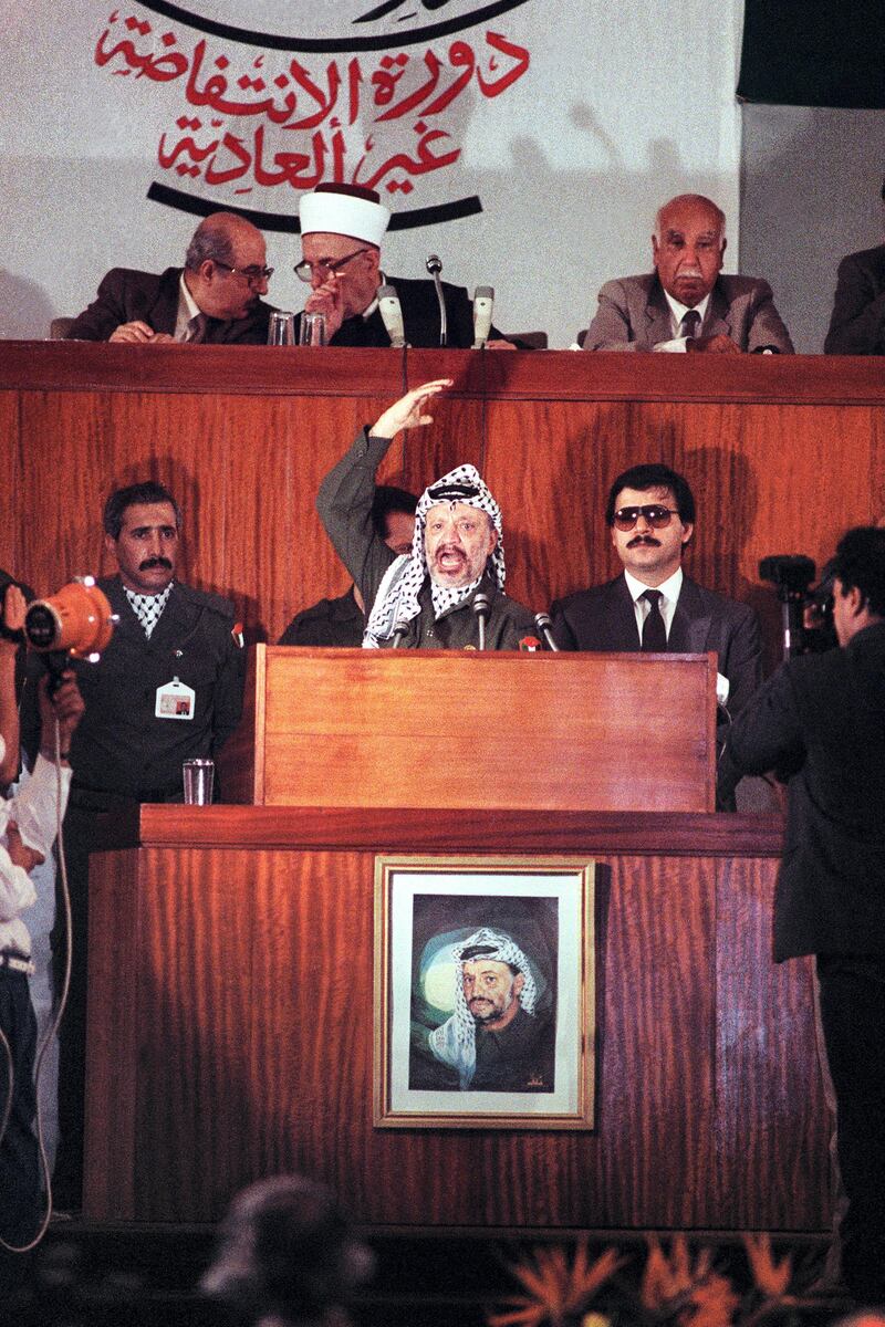 PLO chairman Yasser Arafat delivers a speech to the Palestine National Council meeting, convoked to take the historic decision to proclaim a Palestinian state in the Israeli-occupied territories and to recognize Israel, in the Palace of Nations conference hall, 12 November 1988, in Algiers. (Photo by JOEL ROBINE / AFP)