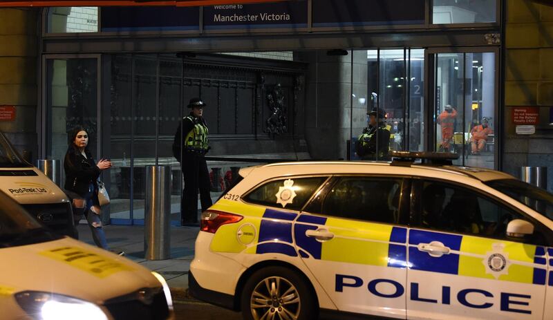 Police officers stand near a cordon at Manchester Victoria Station, in Manchester on January 1, 2019, following a stabbing on December 31, 2018. - A man, a woman and a police officer were being treated for knife injuries, police said Monday, after a stabbing at a railway station in the British city of Manchester. (Photo by Paul ELLIS / AFP)