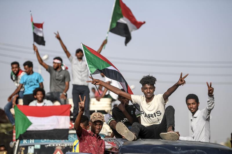 Sudanese protesters from the city of Kassala, sitting atop a bus, arrive to join the sit-in outside the army headquarters in the capital Khartoum on April 27, 2019.  AFP