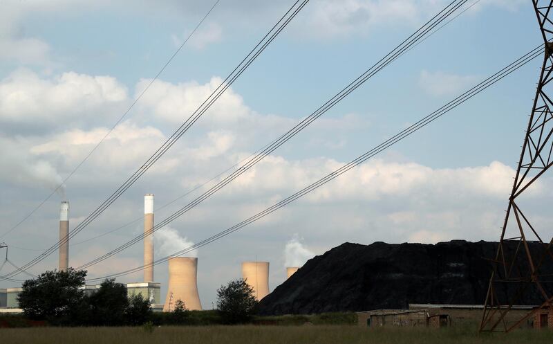 FILE PHOTO: A heap of coal is seen beneath power lines near an Eskom power station in Duhva, South Africa, February 18, 2020. REUTERS/Mike Hutchings/File Photo