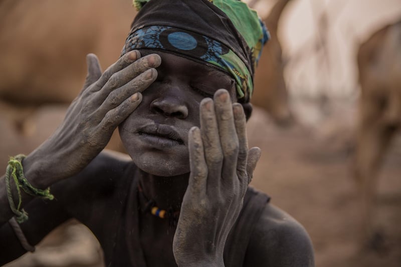 A Sudanese boy covers his face with ash, which acts as a mosquito repellent.
