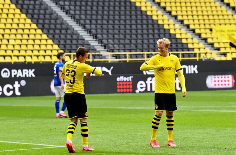 Dortmund's Thorgan Hazard celebrates scoring their third goal with Julian Brandt as play resumes behind closed doors following the outbreak of the coronavirus disease. REUTERS