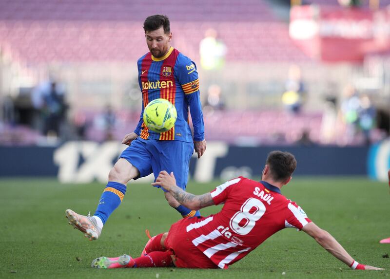 Barcelona's Lionel Messi is challenged by Saul Niguez of Atletico. Reuters