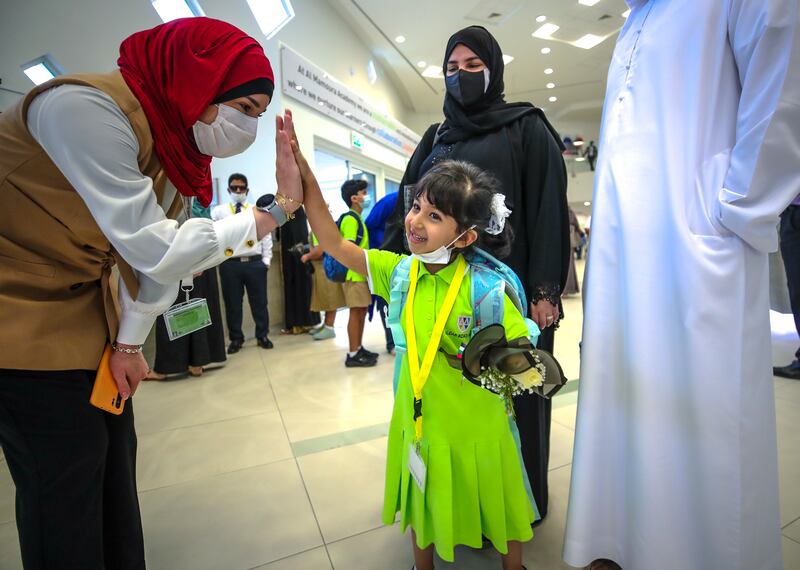 A young pupil greets a member of staff on the first day of school at Al Mamoura Academy. Victor Besa / The National