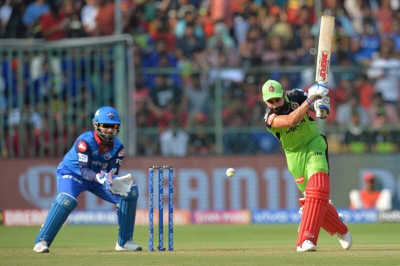 Royal Challengers Bangalore batsman and captain Virat Kohli (R) plays a shot while Delhi Capitals wicketkeeper Rishab Pant looks on during the 2019 Indian Premier League (IPL) Twenty20 cricket match between Royal Challengers Bangalore and Delhi Capitals at The M. Chinnaswamy Stadium in Bangalore on April 7, 2019. (Photo by Manjunath KIRAN / AFP) / ----IMAGE RESTRICTED TO EDITORIAL USE - STRICTLY NO COMMERCIAL USE-----