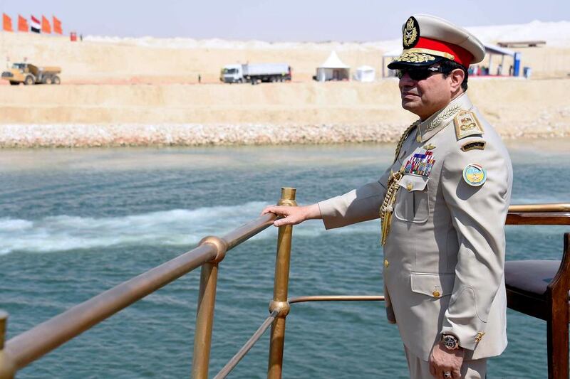 Egyptian president Abdel Fattah El Sisi stands on a yacht leading a naval flotilla during a ceremony on August 6, 2015 to unveil a new waterway at the Suez Canal. EGYPTIAN PRESIDENCY / MOHAMED ABDELMOATY / AFP