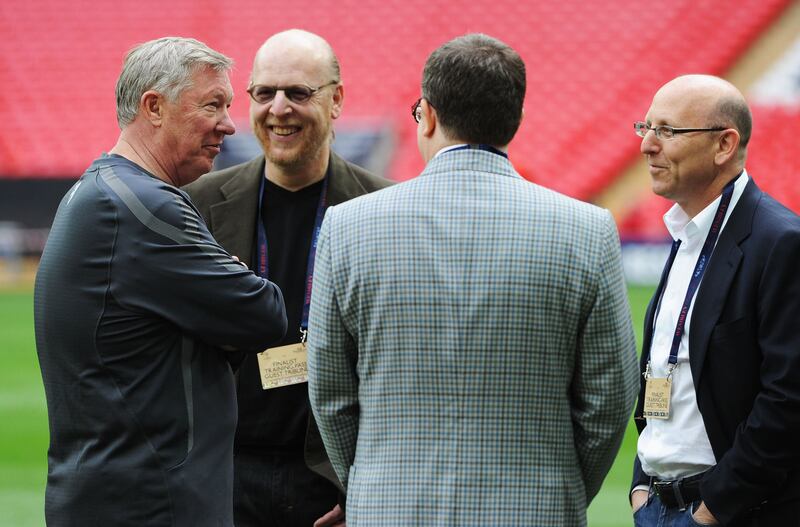 Sir Alex Ferguson speaks with Avram, Bryan and Joel Glazer during a training session prior to the UEFA Champions League final against Barcelona at Wembley Stadium in 2011