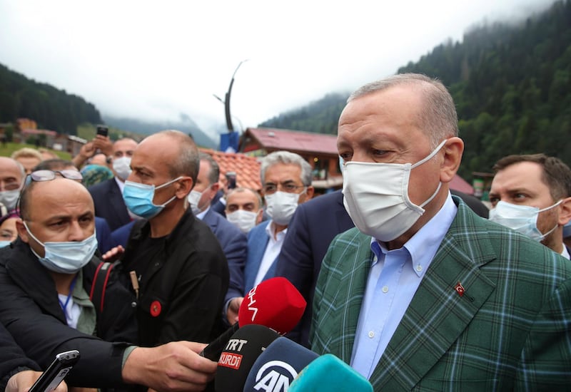 Turkey's President Recep Tayyip Erdogan wearing a face mask to protect against the spread of coronavirus, speaks to the media in Ayder village in the Black Sea city of Rize, Turkey, Sunday, Aug. 16, 2020. Turkey's health minister says the number of new COVID-19 infections Saturday has hit its highest in 45 days and announced 1,256 new cases.(Turkish Presidency via AP, Pool)