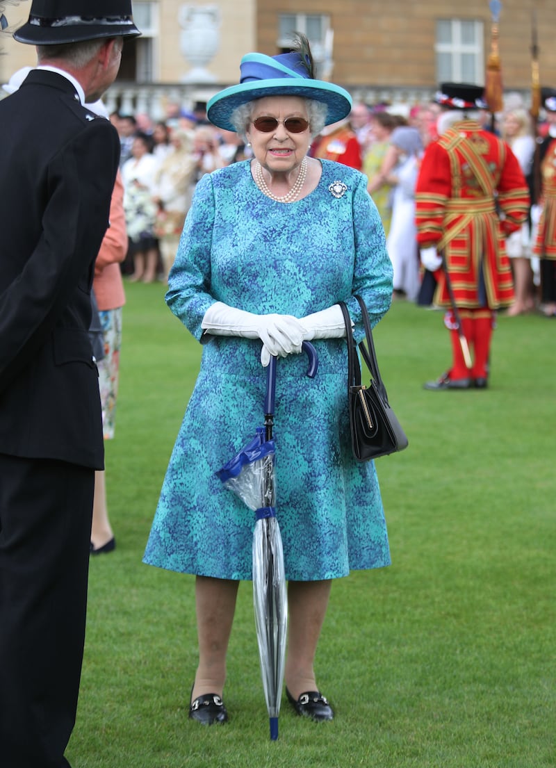 Queen Elizabeth II, wearing turquoise, hosts a Garden Party at Buckingham Palace on May 31, 2018. Getty Images