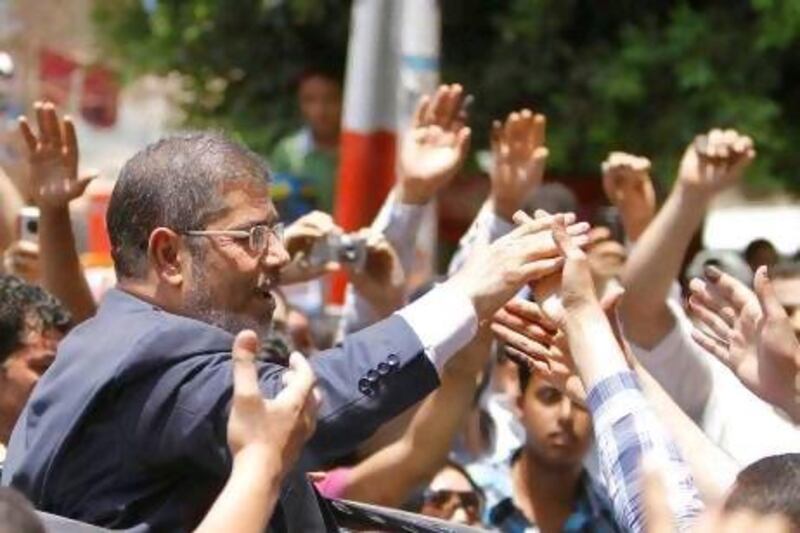 Egypt's new president Mohammed Morsi waves to supporters outside a polling station in Zagazig, northeast of Cairo, earlier this month.