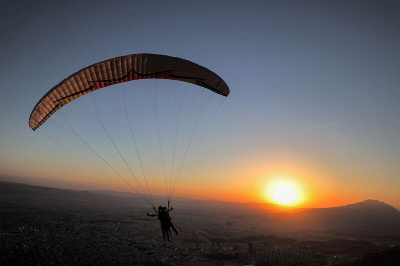 Members of the Sulaymaniyah paragliding team launch at sunset from Mount Azmar to glide over the city of Sulaymaniyah in north-eastern Iraq's autonomous Kurdistan region.