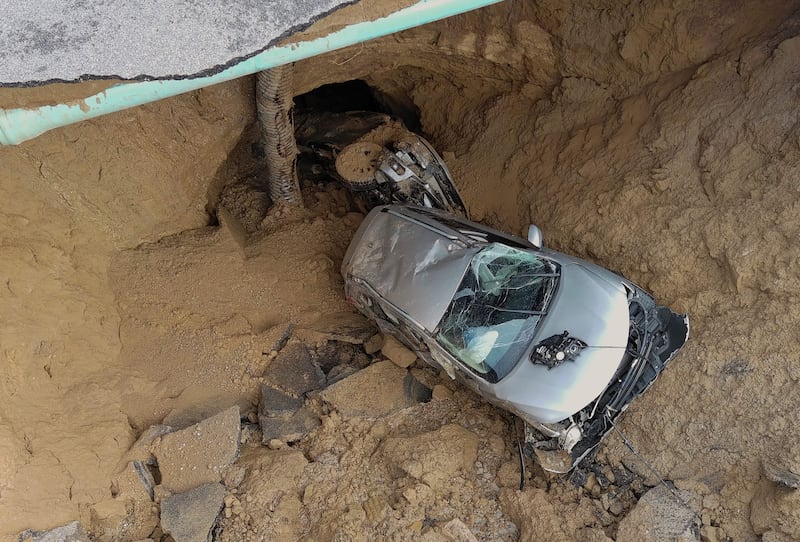 Two cars were sucked into a sinkhole that opened during a day of relentless rain near Los Angeles. AFP