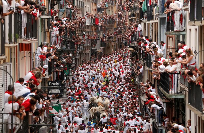 Revellers sprint in front of bulls and steers during the first running of the bulls at the San Fermin festival in Pamplona, Spain. Reuters