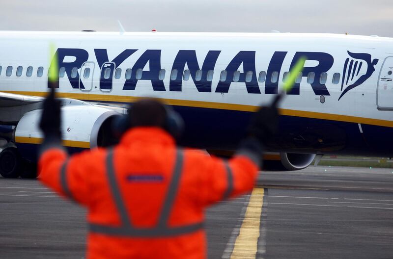 An employee uses glow sticks to guide a Ryanair Holdings Plc aircraft into position at Dublin Airport, operated by Dublin Airport Authority, in Dublin, Ireland, on Friday, Nov. 25, 2016. Ryanair provides low fare passenger airline services to destinations in Europe. Photographer: Chris Ratcliffe/Bloomberg