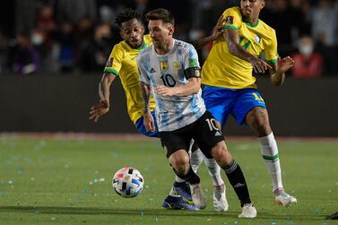 (FILES) In this file photo taken on November 17, 2021 Argentina's Lionel Messi (C) drives the ball past Brazil's Fred (L) and Eder Militao during their South American qualification football match for the FIFA World Cup Qatar 2022 at the San Juan del Bicentenario stadium in San Juan, Argentina.  (Photo by Juan Mabromata  /  AFP)