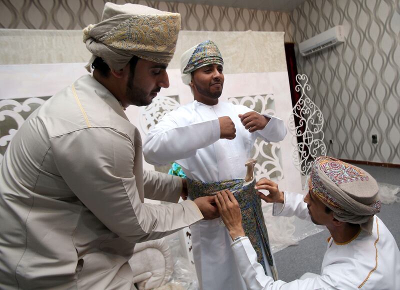 Omani grooms dress up ahead of a mass wedding ceremony of 25 couples in the Al-Mudhaibi province on July 7, 2017. / AFP PHOTO / MOHAMMED MAHJOUB