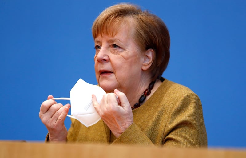 German Chancellor Angela Merkel takes her mask off as she arrives to hold a news conference about the current situation of the spread of the coronavirus disease (COVID-19), in Berlin, Germany, January 21, 2021. REUTERS/Fabrizio Bensch/Pool