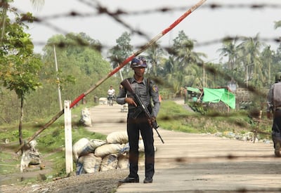 FILE - In this Sept. 6, 2017, file photo, a Myanmar police officer stands guard at a checkpoint in Shwe Zar village in the northern Rakhine state of Myanmar. Amnesty International, in a report issued Wednesday, May 29, 2019, says it has found new evidence of war crimes and human rights violations in Rakhine State, where the armed forces two years ago carried out a brutal counterinsurgency campaign that drove more than 700,000 members of the Muslim Rohingya minority to flee across the border to Bangladesh. (AP Photo/File)