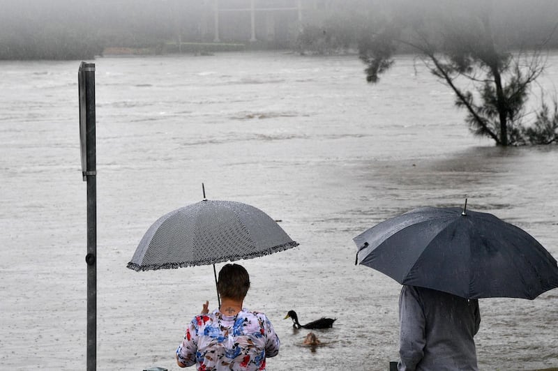 Residents look at the overflowing Nepean river in Penrith suburb. AFP