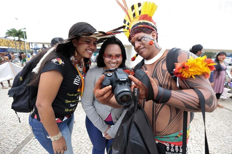 Indigenous people of different ethnic groups look at a photograph on a camera during a protest against the Indian policy of President Dilma Rousseff’s government and the costs of the 2014 World Cup in front of the Planalto Palace in Brasilia. Joedson Alves / Reuters
