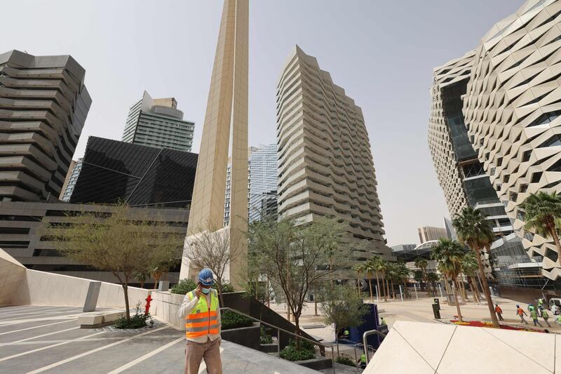 (FILES) This file photo taken on March 16, 2021, shows workers in the King Abdullah Financial District (KAFD) in the Saudi capital Riyadh. Dangling off sun-dappled skyscrapers, construction workers put finishing touches to a long-delayed financial district in Riyadh that is taking centre stage as competition heats up with Dubai to attract foreign firms. / AFP / Fayez Nureldine
