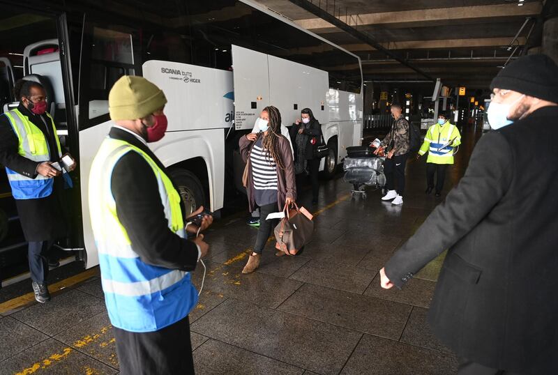 Passengers are escorted by security to a coach destined for the Radisson Blu Hotel near Heathrow airport. EPA / Getty