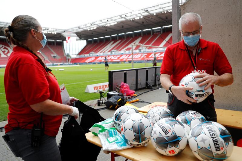 Footballs are cleaned during the match at the Opel Arena. Getty