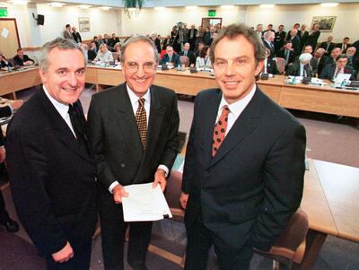 FILE - In this April 10, 1998, file photo, from right, British Prime Minister Tony Blair, U.S. Sen. George Mitchell, and Irish Prime Minister Bertie Ahern, pose together after they signed the Good Friday Agreement for peace in Northern Ireland. The chaotic scenes during a week of violence on the streets of Northern Ireland have stirred memories of decades of Catholic-Protestant conflict, known as "The Troubles." A 1998 peace deal ended large-scale violence but did not resolve Northern Ireland's deep-rooted tensions. (AP Photo/File)