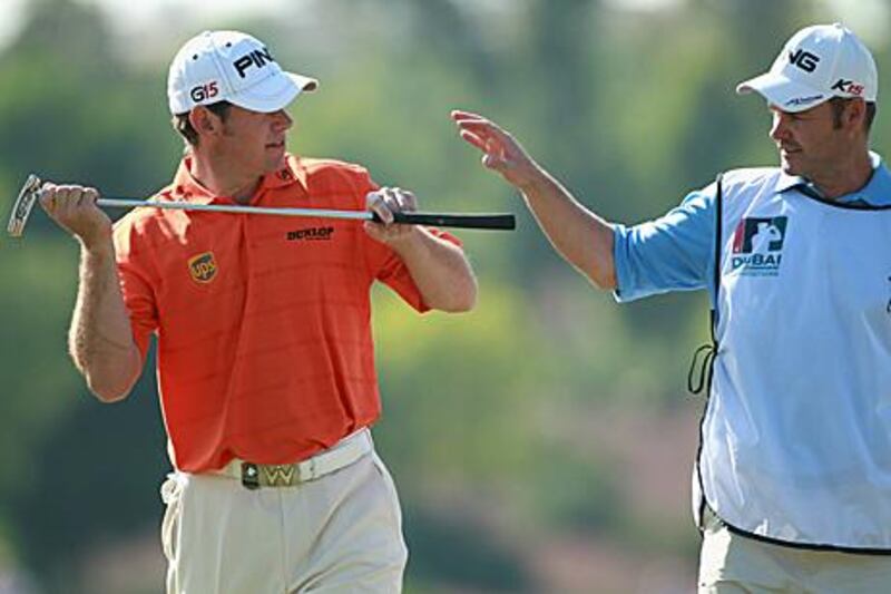 Lee Westwood, left, shares a light moment with Billie Foster, his caddie, during the second round  in Dubai yesterday.