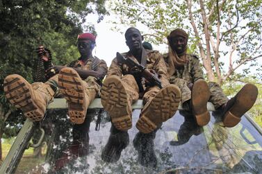 Three rebel soldiers sit atop their vehicle on the road between Kaga Bandor oand N'Dele, two rebel-held towns