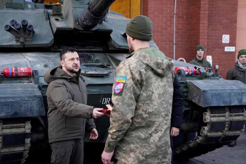 Mr Zelenskyy presents a medal as he meets Ukrainian troops being trained to command Challenger 2 tanks in Lulworth. AFP