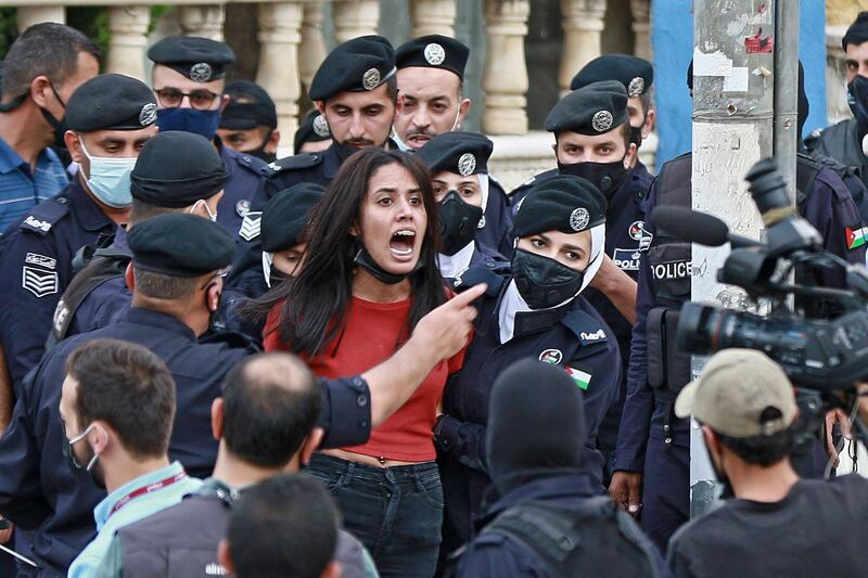 Police officers restrain a protester during a demonstration in solidarity with the Palestinian people, near the Israeli embassy in Jordan's capital Amman. AFP