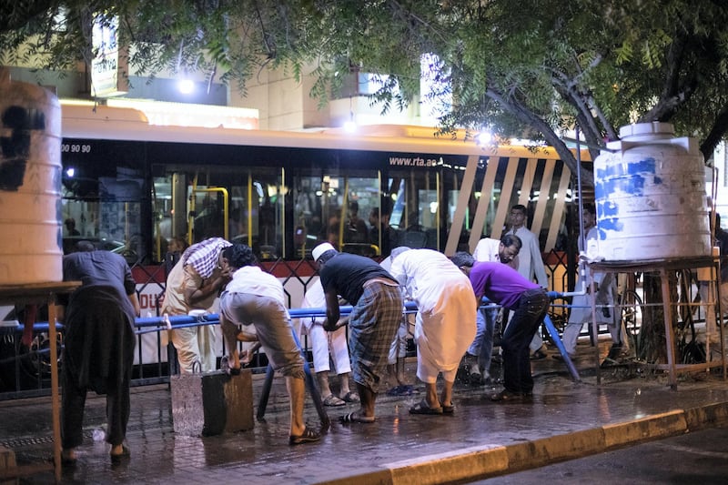 DUBAI, UNITED ARAB EMIRATES - May 17 2019.

Men ablute outside the Steel mosque on a rainy evening in Dubai .

(Photo by Reem Mohammed/The National)

Reporter: 
Section: NA