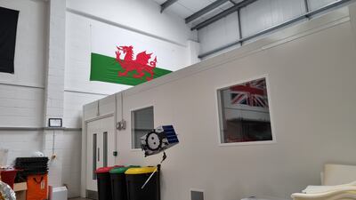 A Welsh flag hangs over a model of Space Forge's prototype satellite at the company's workshop in Cardiff. Tim Stickings / The National