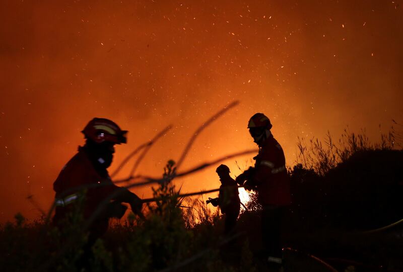 Firefighters battle a wild fire raging near houses on the outskirts of Obidos, Portugal. Armando Franca / AP Photo