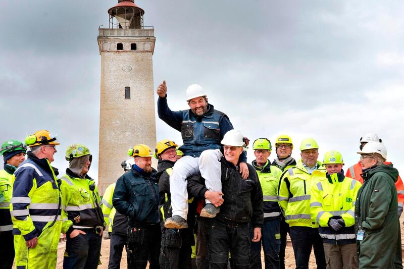 Workers celebrate after the lighthouse in Rubjerg Knude was being moved away from the coastline between Lonstrup and Lokken, Jutland, Denmark. AFP