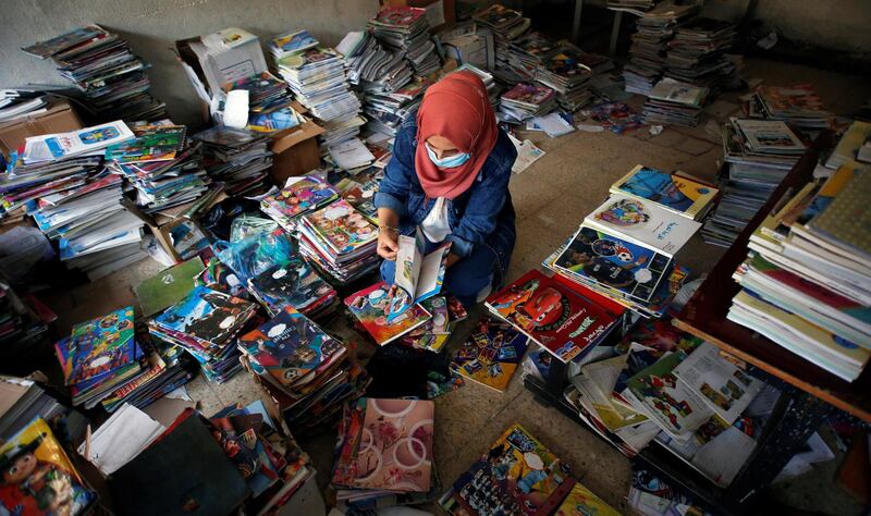 An Iraqi teacher sorts the school books until they are handed over to pupils after schools reopen in Baghdad, Iraq. Reuters