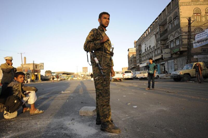 A Houthi Shiite fighter wearing an army uniform stands guard outside of a sports stadium during a rally in Sanaa, Yemen (AP Photo/Hani Mohammed)